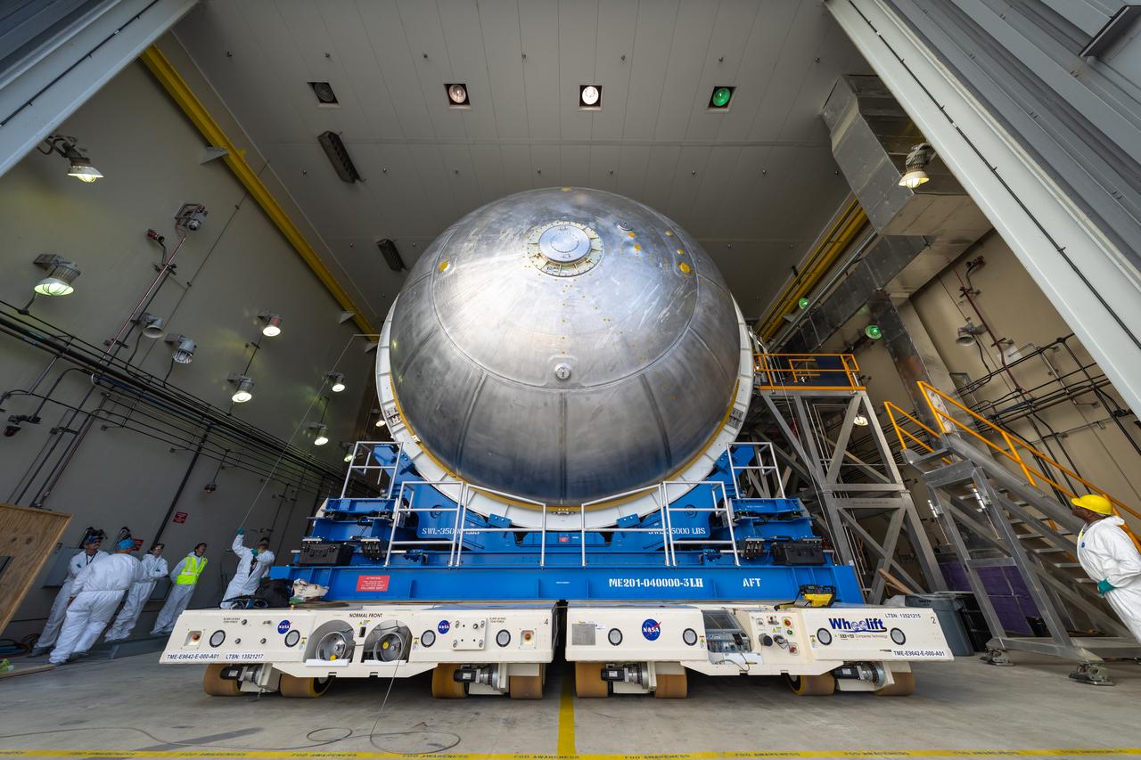 Teams move the core stage liquid hydrogen tank for the Artemis III mission to a priming cell near the Vertical Assembly Building at NASA’s Michoud Assembly Facility in New Orleans Nov. 21. Technichians will sand down and prepare the suface of the tank before coating it in a primer. Primer is applied to the barrel section of the tank by an automated robotic tool, whereas the forward and aft domes are primed manually.   Once priming is complete, technicians with NASA and Boeing, the SLS core stage prime contractor, will apply a foam-based thermal protection system, which protects the propellant tank from the extreme temperatures it will face during launch and flight while also regulating the super-chilled propellant within it. The propellant tank is one of five major elements that make up the 212-foot-tall rocket stage. The core stage, along with its four RS-25 engines, produce two million pounds of thrust to help launch NASA’s Orion spacecraft, astronauts, and supplies beyond Earth’s orbit and to the lunar surface for Artemis.   